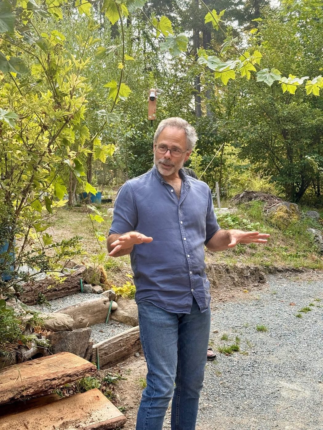 Gord Baird gesturing mid-conversation in the Eco-Sense food forest